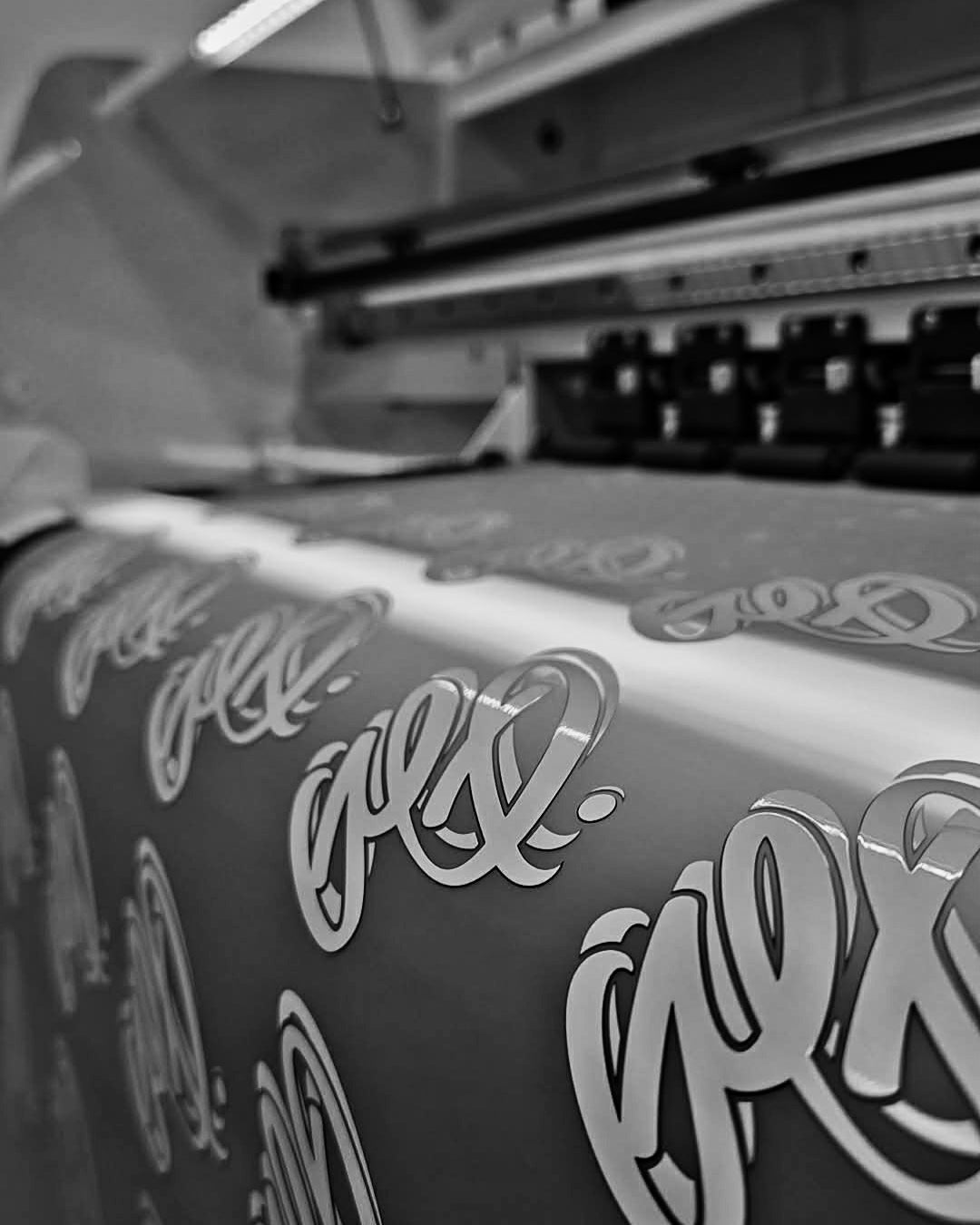 Textile with a pattern being printed on a DTF (direct-to-film) printing machine at Ōtautahi Print Co.