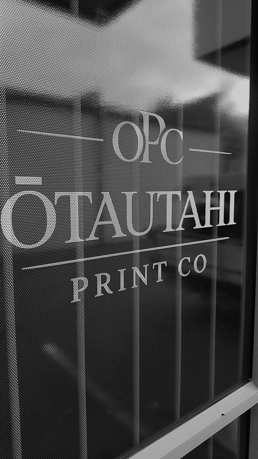 Glass door with the 'Ōtautahi Print Co' branding on a black background